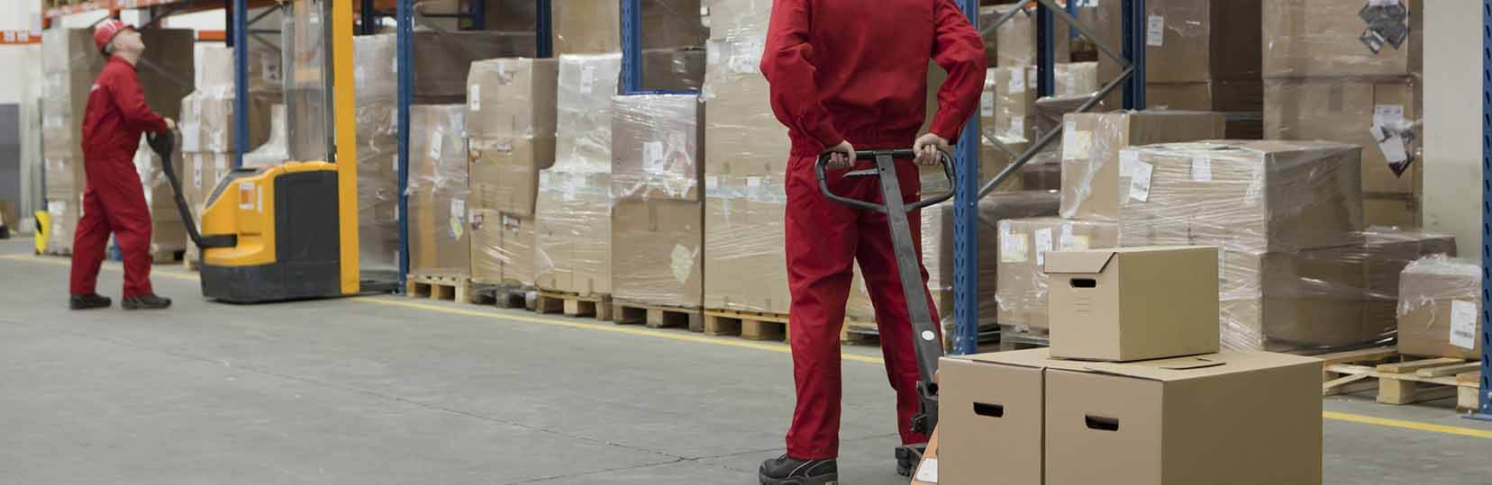 Two men wearing red suits inside a storage facility